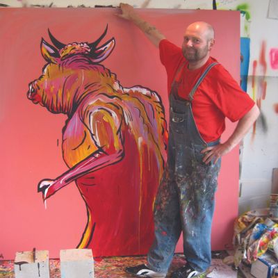 Artist Adam Cullen standing in front of his art